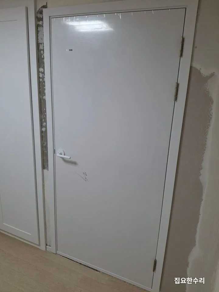 문틀과 흰색 여닫이 문 설치가 끝나 보일러실 입구가 정리된 모습 (병점 출장 시공)