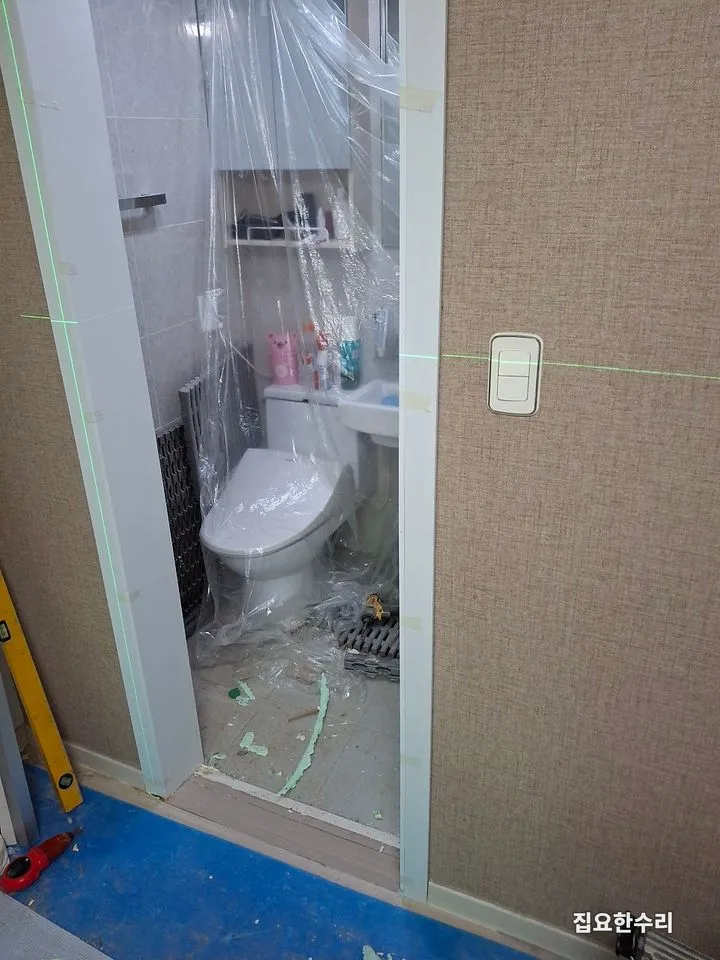 레이저 수평기로 기준선을 잡고 욕실 내부를 비닐로 보양한 모습 (수원 출장 시공)