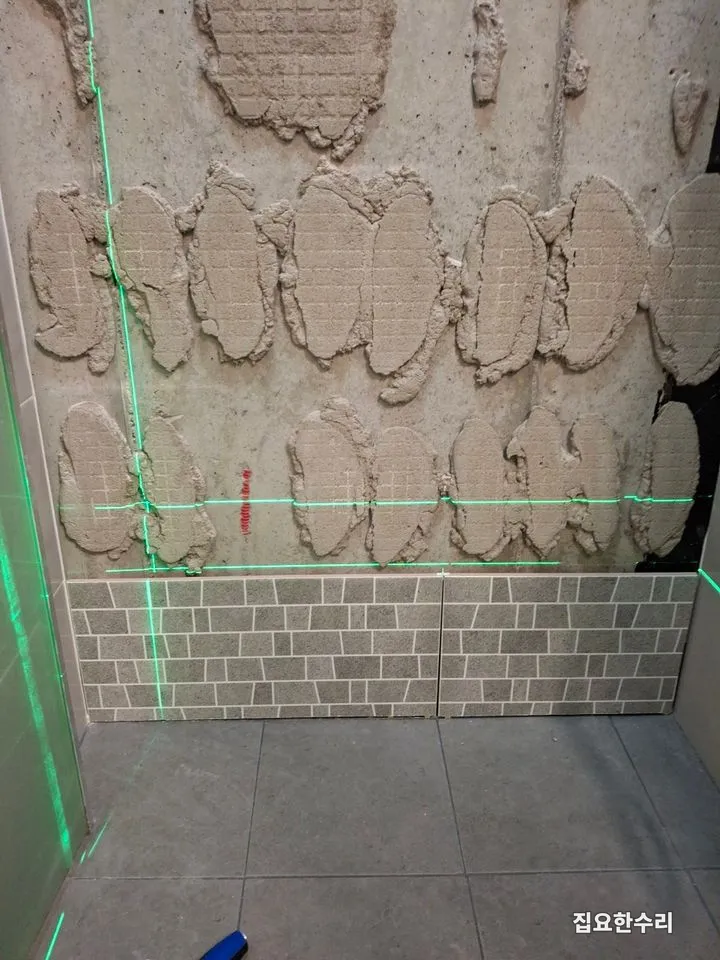 레이저 레벨기로 기준선을 잡고 새 타일 첫 줄을 붙인 모습