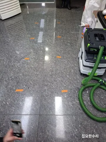 바닥을 두드려 빈 소리가 나는 타일마다 주황색 테이프로 표시한 모습 (안양 출장 시공)