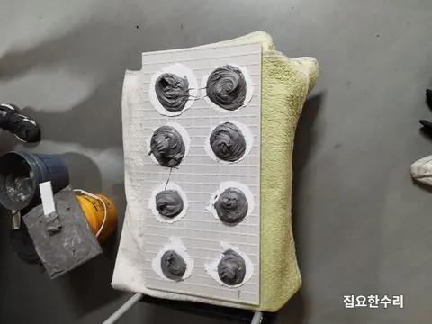 떨어진 아트월 타일 뒷면의 기존 접착제를 갈아내고 에폭시 접착제를 점 형태로 올린 모습 (평촌 출장 시공)