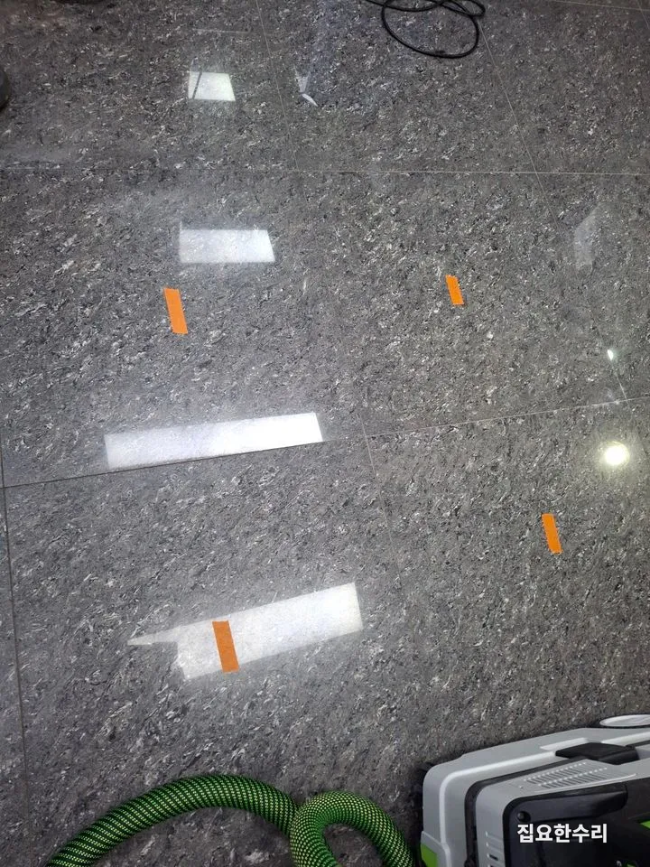 들뜬 타일 표시가 이어진 바닥과 집진기 호스 (안양 출장 시공)