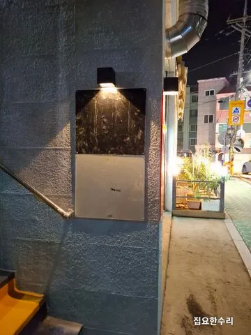 저녁에 점등한 출입구 기둥 LED 벽등이 계단 쪽을 비추는 모습