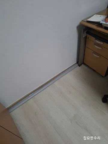 책상 뒤 벽 아래로 몰드 한 줄만 지나가도록 정리된 시공 후 모습 (영통 출장 시공)