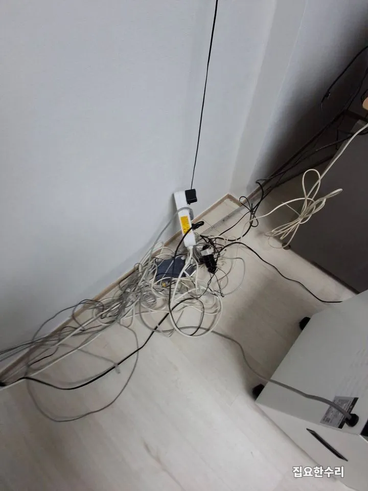 걸레받이 앞에 랜선과 어댑터 케이블이 한 덩어리로 엉켜 있는 모습 (영통 출장 시공)